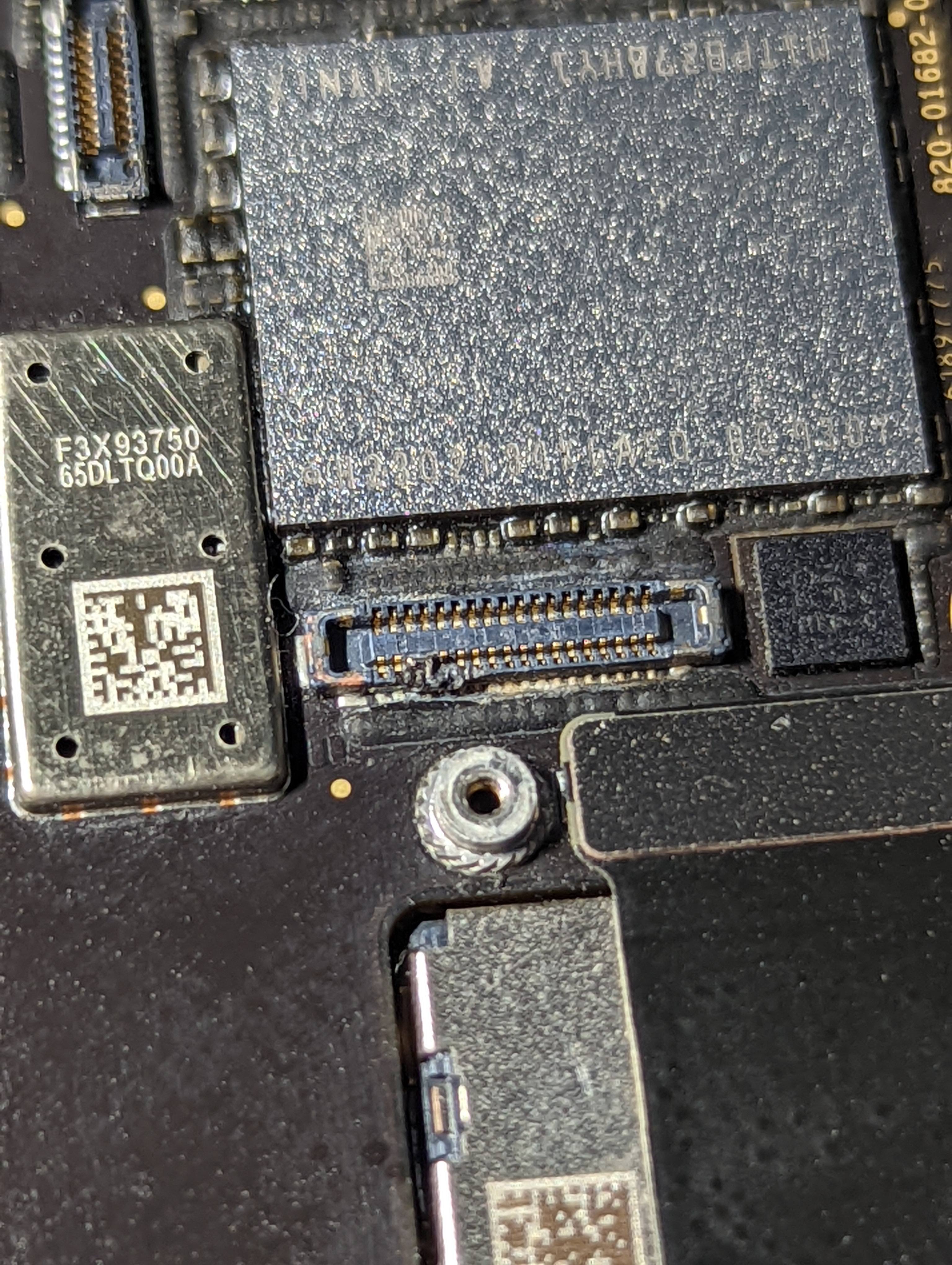 A damaged iPad display connector on the logic board, with crushed pins and a torn housing