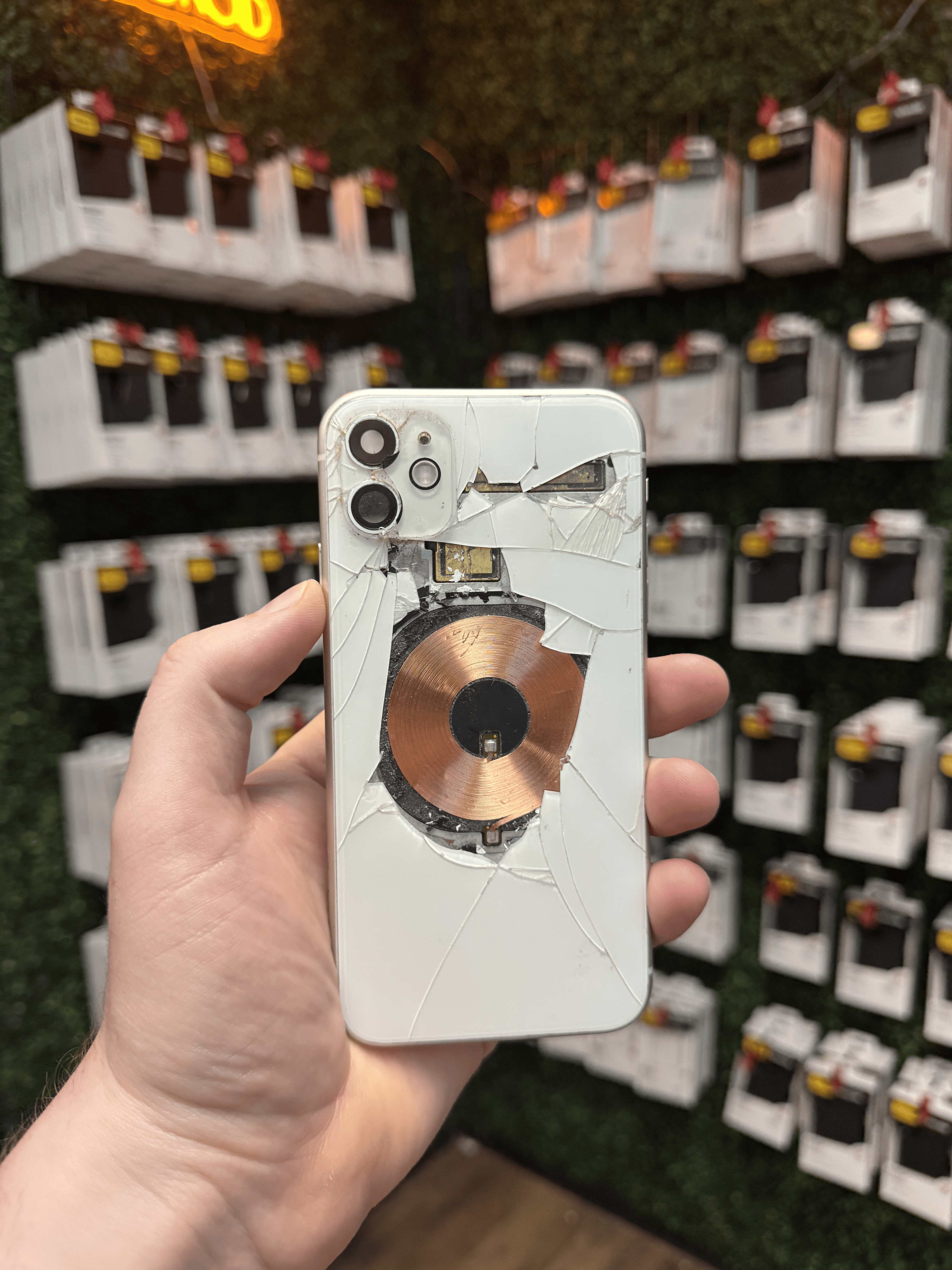 iPhone 11 with severely shattered back glass and internal components exposed, brought in for repair at Charlotte Tech Repair