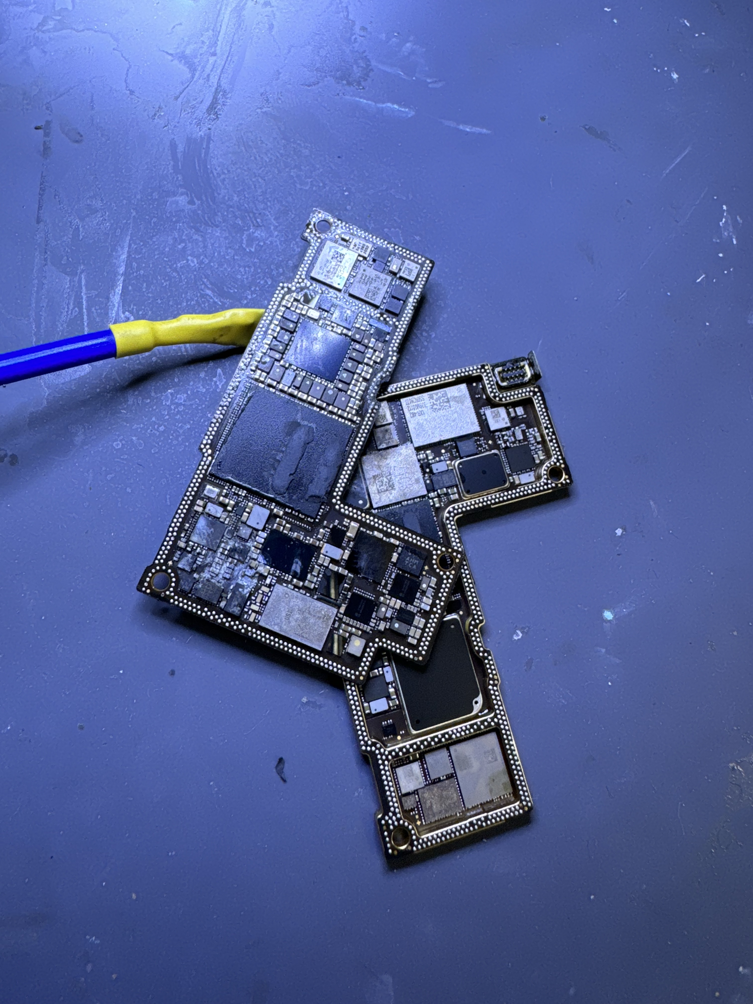 An iPhone logic board separated into its two halves during a VDD_MAIN short diagnostic