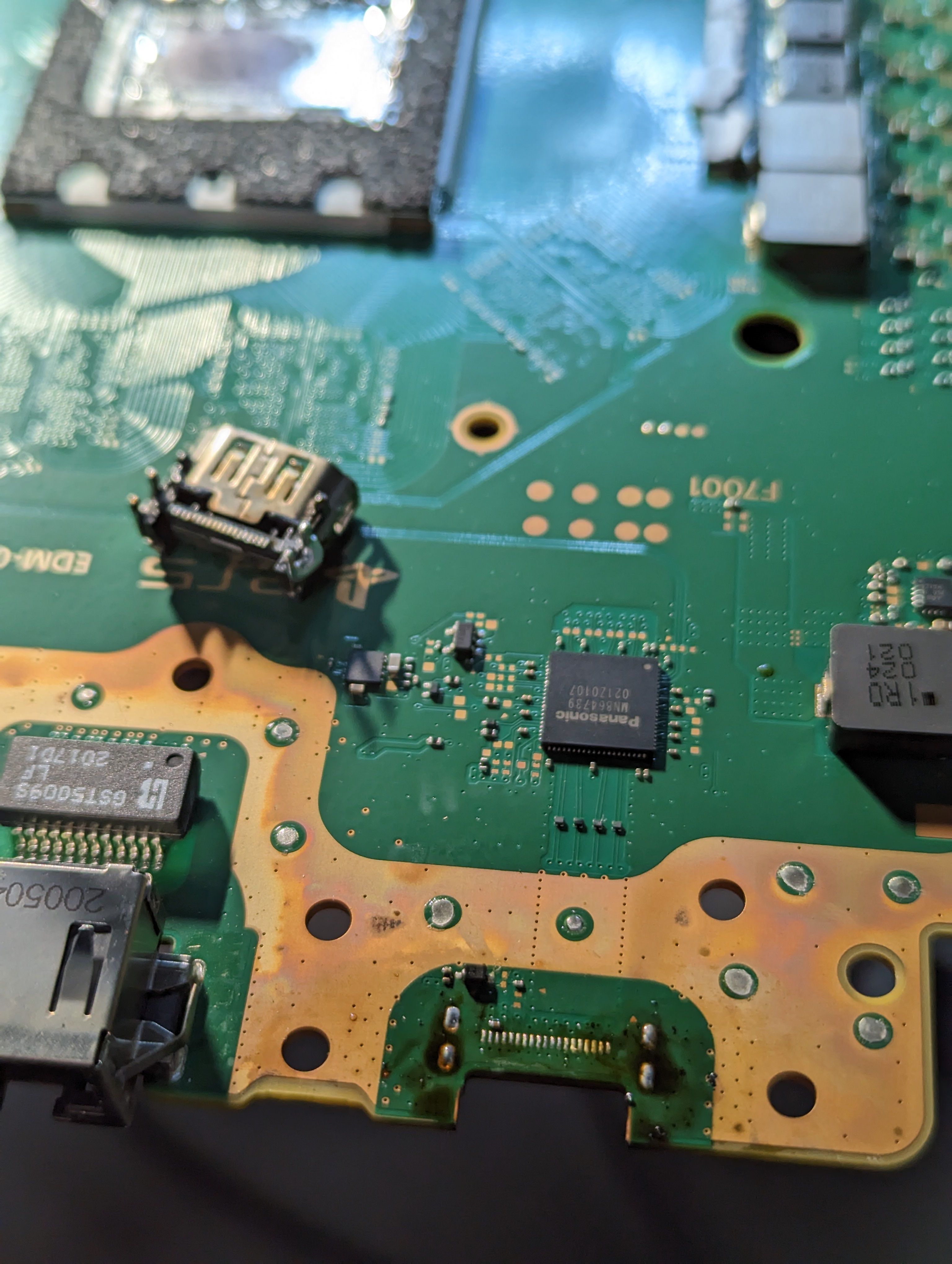A damaged HDMI port on a PS5 motherboard, with the port housing bent and deformed