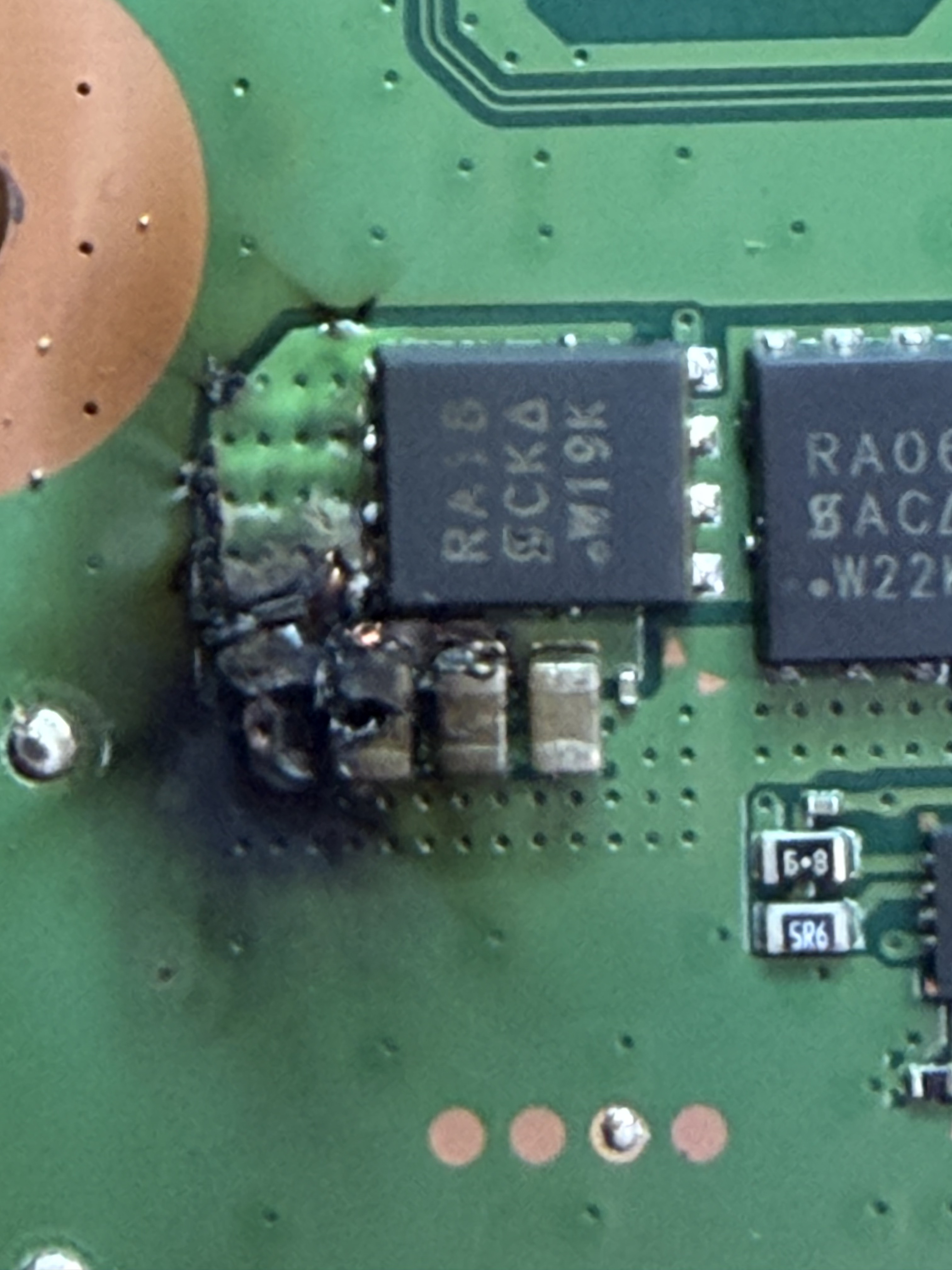 Burnt capacitors and scorching on a PS5 motherboard damaged by a power surge