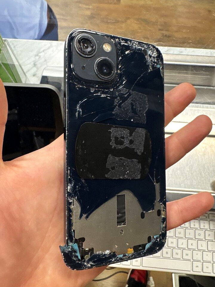 iPhone 13 with visible rear-glass damage before service