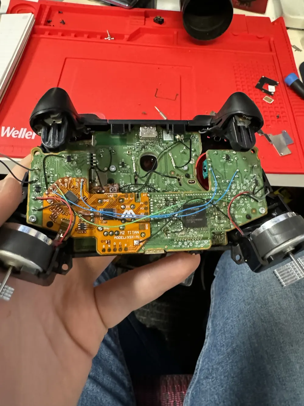 Custom aftermarket Xbox controller opened during stick drift repair at Charlotte Tech Repair — rear shell removed exposing modded PCB with four programmable back paddles and custom wiring